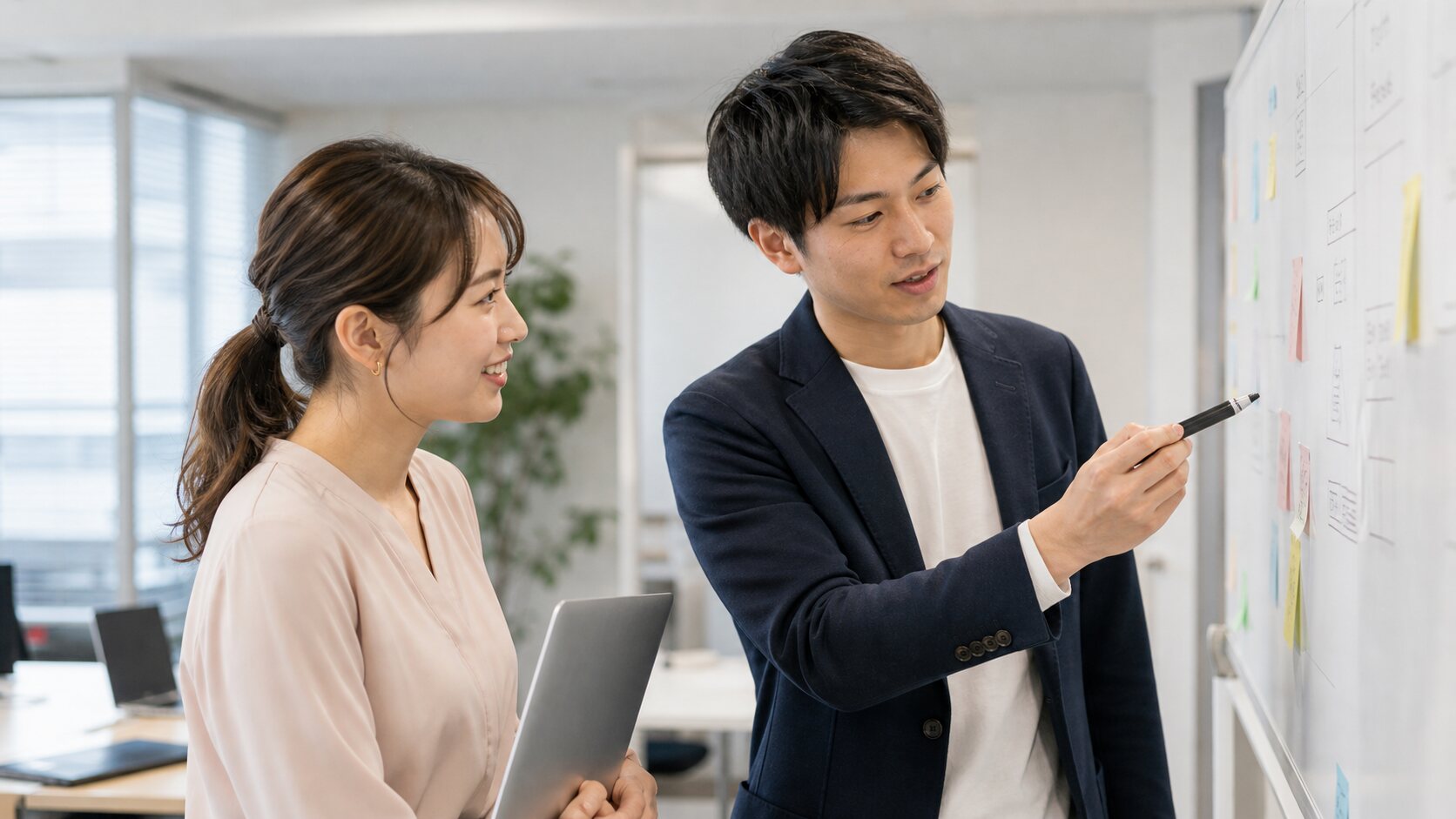 ホワイトボードでタスクを確認するメンバー